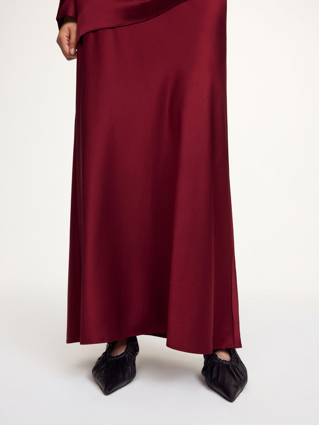 By Malene Birger Barbara burgunder satengskjørt, detalj av asymmetrisk hem og acetat-materiale.