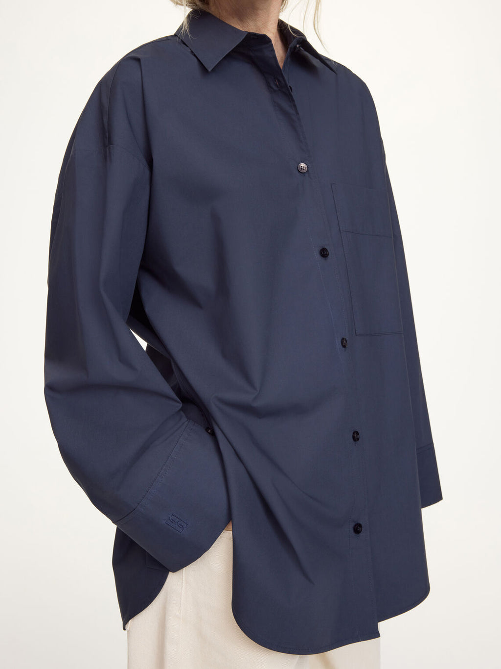 By Malene Birger Derris oversized mørkeblå skjorte, detalj av brystlomme og knapperekke.
