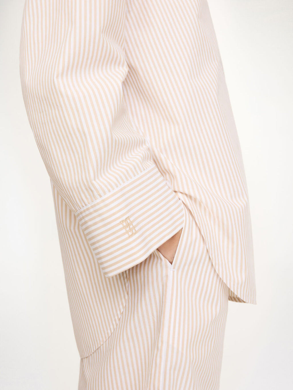 By Malene Birger Derris oversized beige skjorte, detalj av brystlomme og knapperekke.