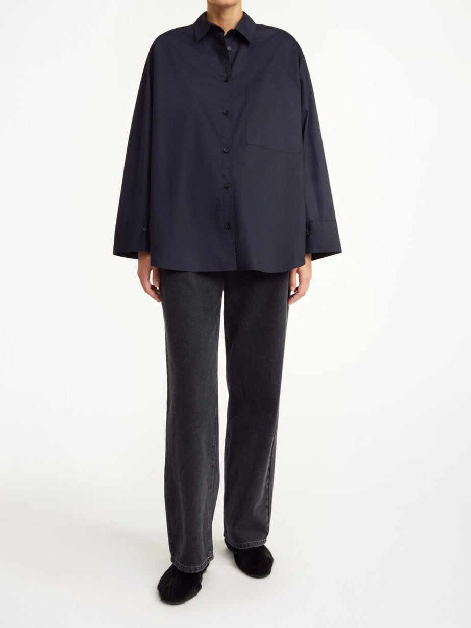 By Malene Birger Derris bomullsskjorte i sort, med en oversized passform og brystlomme, laget av 100% organisk bomull.