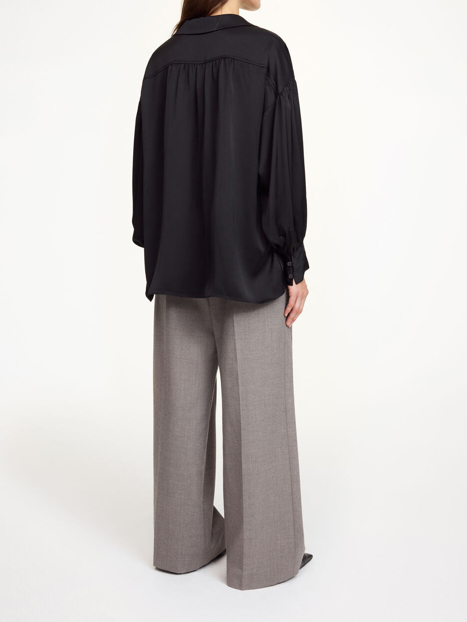 By Malene Birger Leonora oversized satengbluse i sort, løs passform med splitt i sidene og sidelommer.