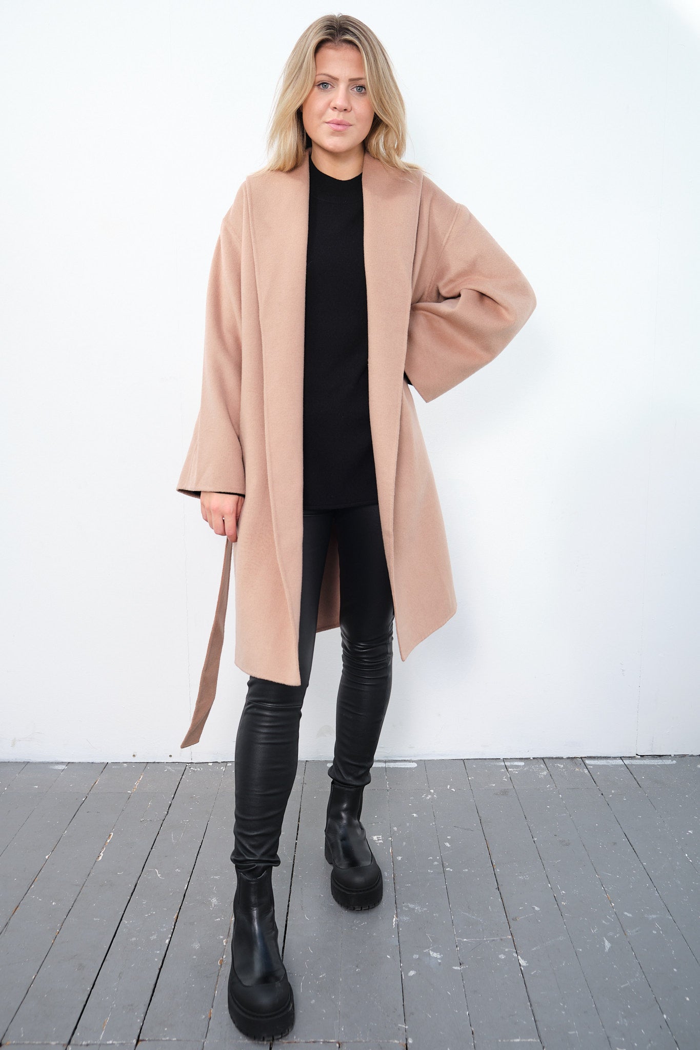 By Malene Birger Trullas kåpe i brun, med en sjal-lignende krage og en rett passform, laget av 100% ull.