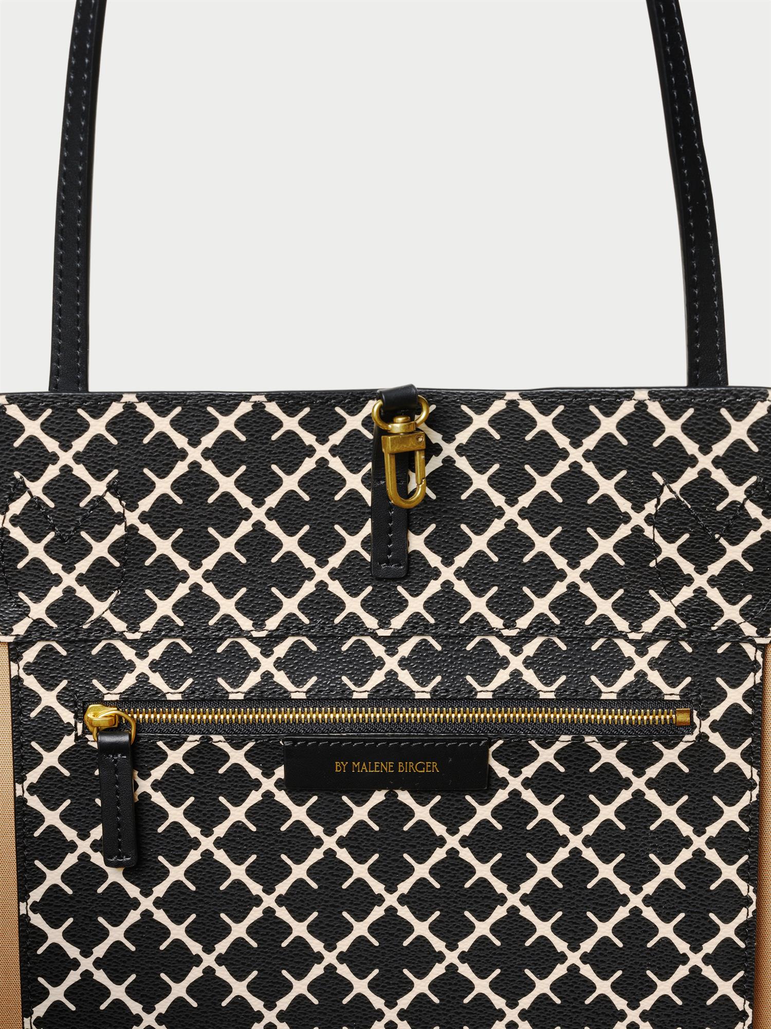 ABI TOTE veske fra By Malene Birger i fargen sort, laget i polyvinylklorid med Signature Flower print og skinnhåndtak. Romslig modell med innvendig lomme.
