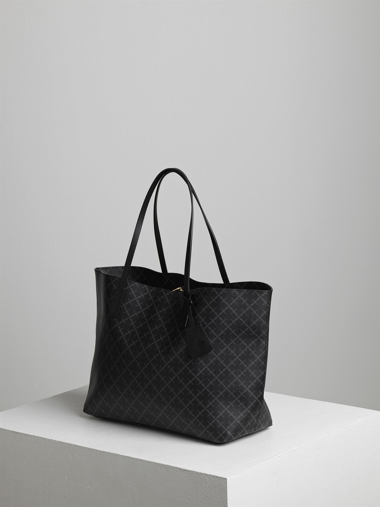 By Malene Birger Abigail veske i koksgrå, med Signature Flower-print og skinndetaljer, laget av polyvinylklorid.