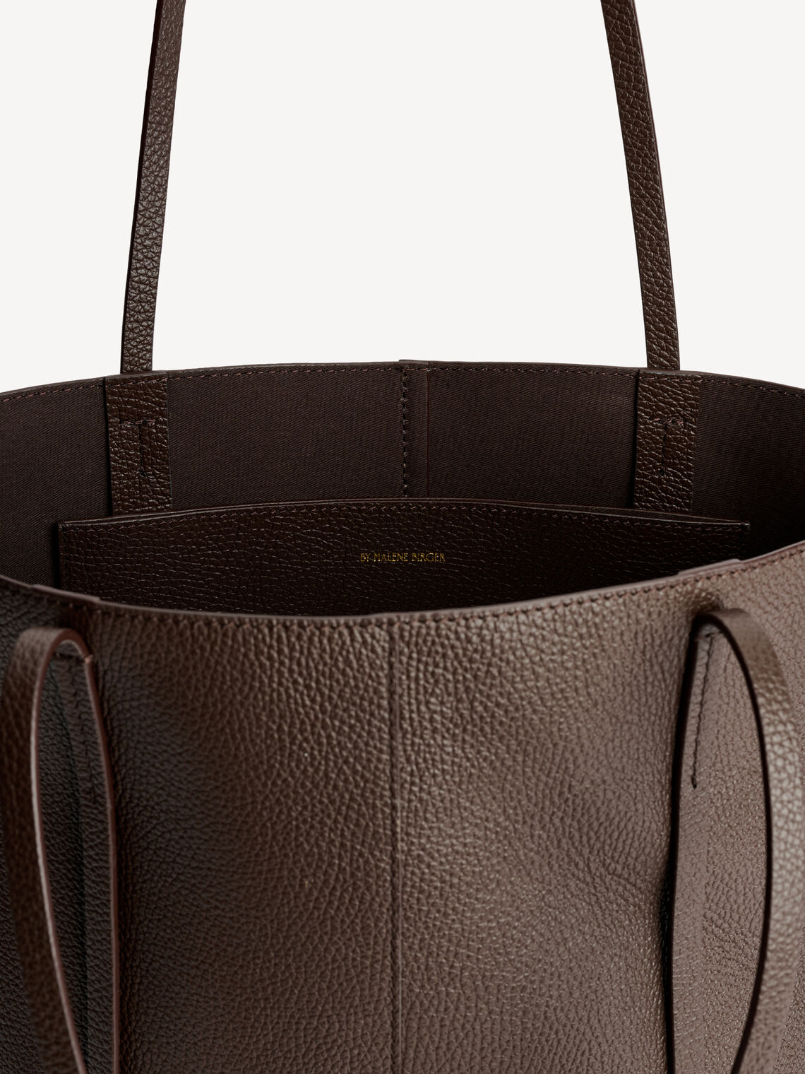 By Malene Birger Abilso veske i mørkebrun, laget av kuskinn med struktur og en tote-form.