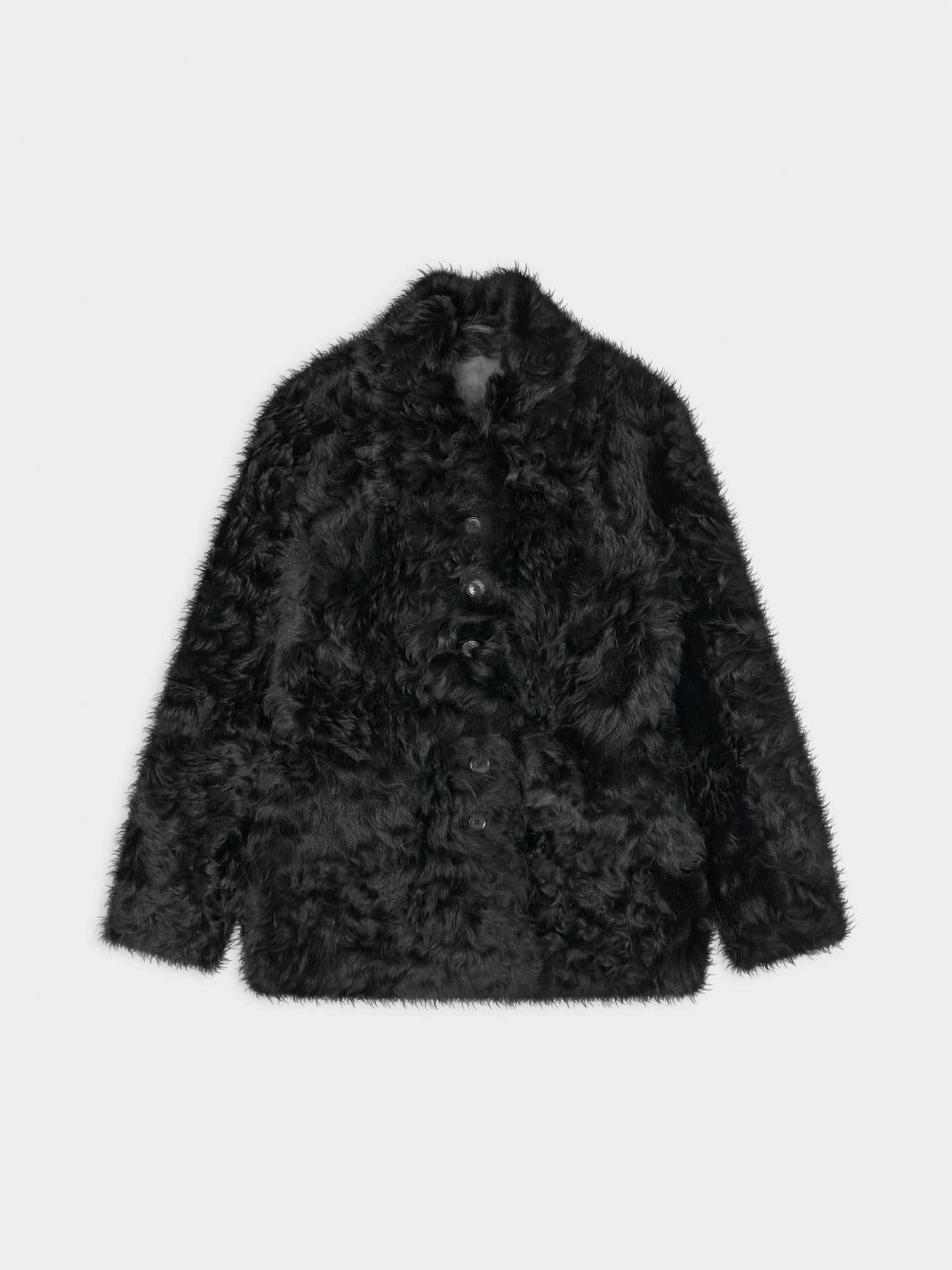 ADELINE shearlingjakke fra By Malene Birger i fargen sort, laget i 100% ekte kalveskinn med naturlig hår. Vrengbar med langhåret finish på den ene siden og glatt skinn på den andre, lukkes med knapper i front.