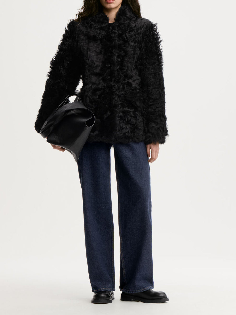 ADELINE shearlingjakke fra By Malene Birger i fargen sort, laget i 100% ekte kalveskinn med naturlig hår. Vrengbar med langhåret finish på den ene siden og glatt skinn på den andre, lukkes med knapper i front.