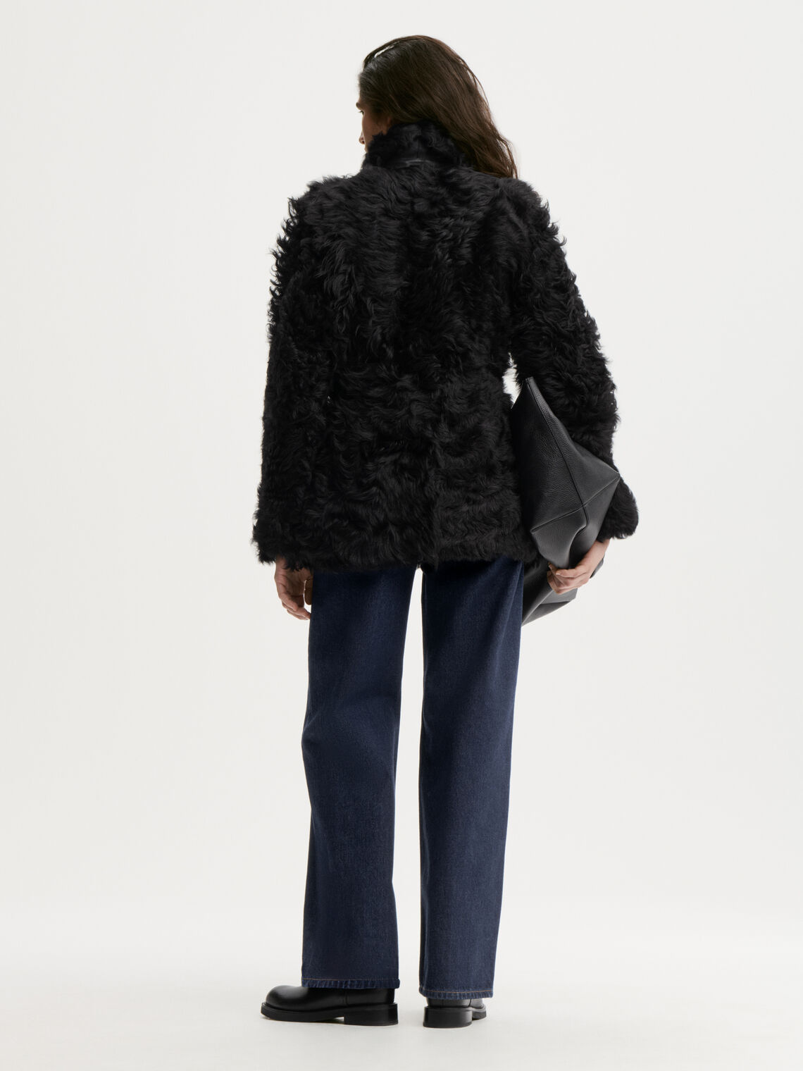 ADELINE shearlingjakke fra By Malene Birger i fargen sort, laget i 100% ekte kalveskinn med naturlig hår. Vrengbar med langhåret finish på den ene siden og glatt skinn på den andre, lukkes med knapper i front.