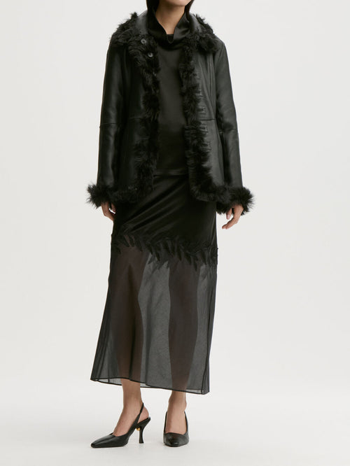 ANGELINA skjørt fra By Malene Birger i fargen sort, laget i 76% acetat og 24% polyester sateng. A-linjet silhuett med gjennomsiktig parti nederst og glidelås i siden.
