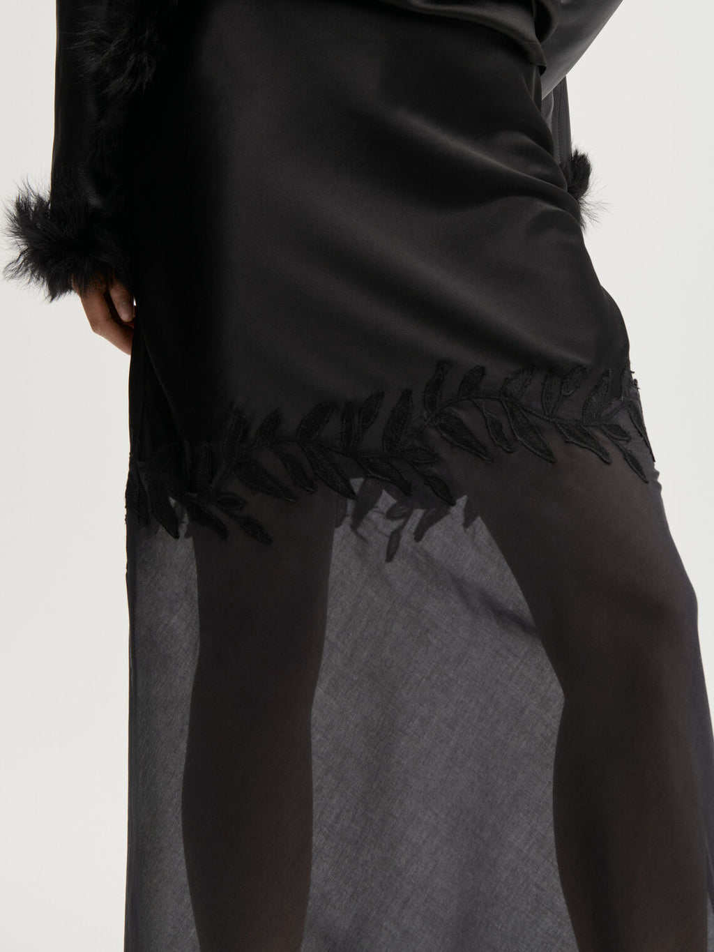ANGELINA skjørt fra By Malene Birger i fargen sort, laget i 76% acetat og 24% polyester sateng. A-linjet silhuett med gjennomsiktig parti nederst og glidelås i siden.