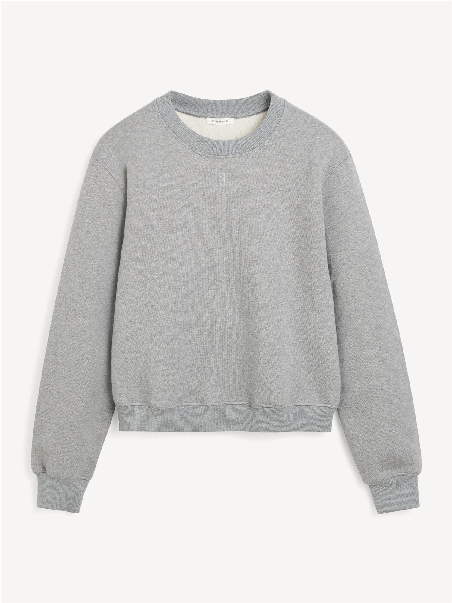 By Malene Birger Apalia genser i grå, laget av 100% organisk bomull, med brodert monogram på brystet og ribbestrikkede avslutninger.