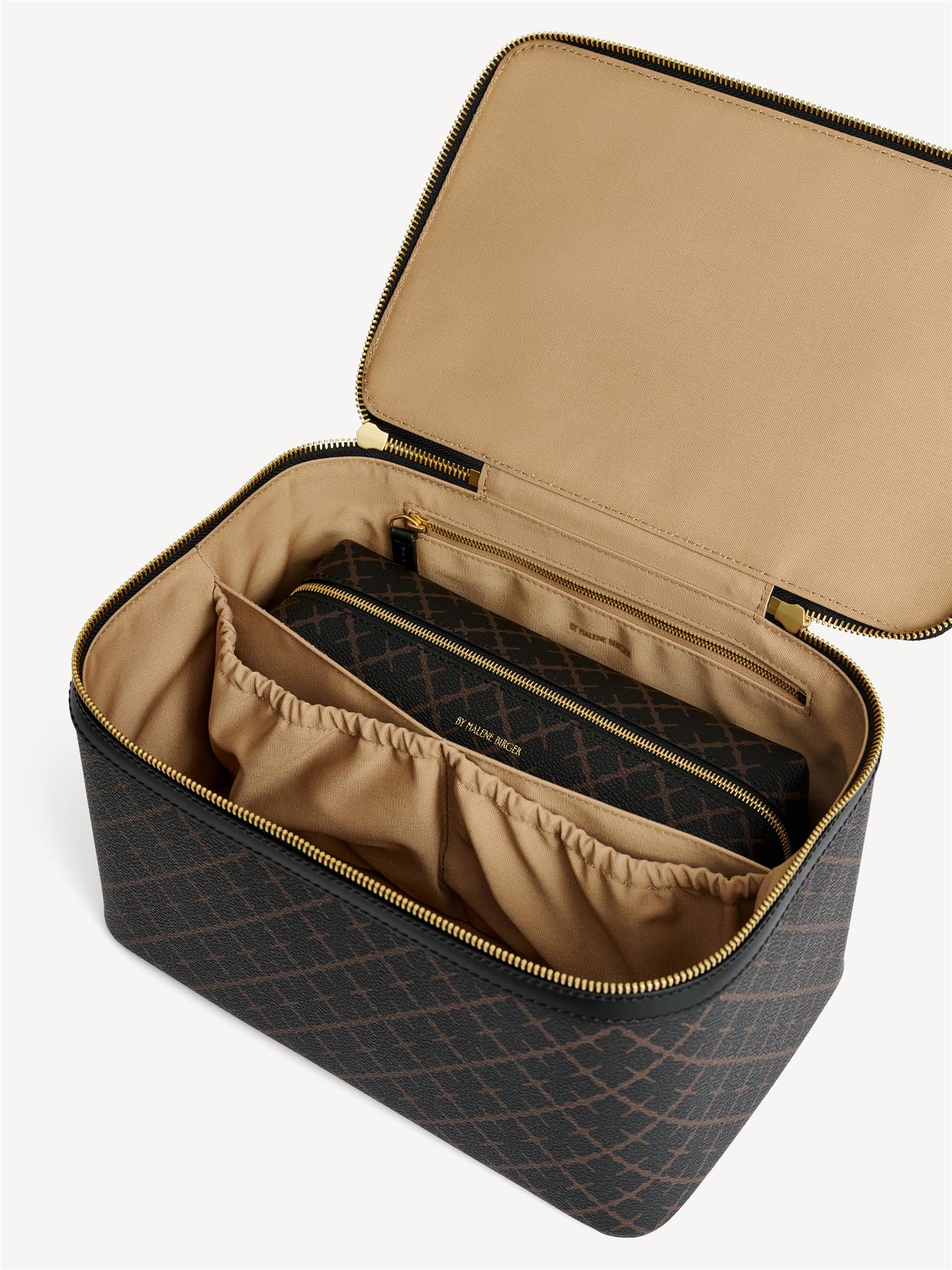 By Malene Birger Bae Beauty Box toalettmappe i brun, laget av polyvinylklorid med Signature Flower-print, med flere rom og en ekstra sminkepung.