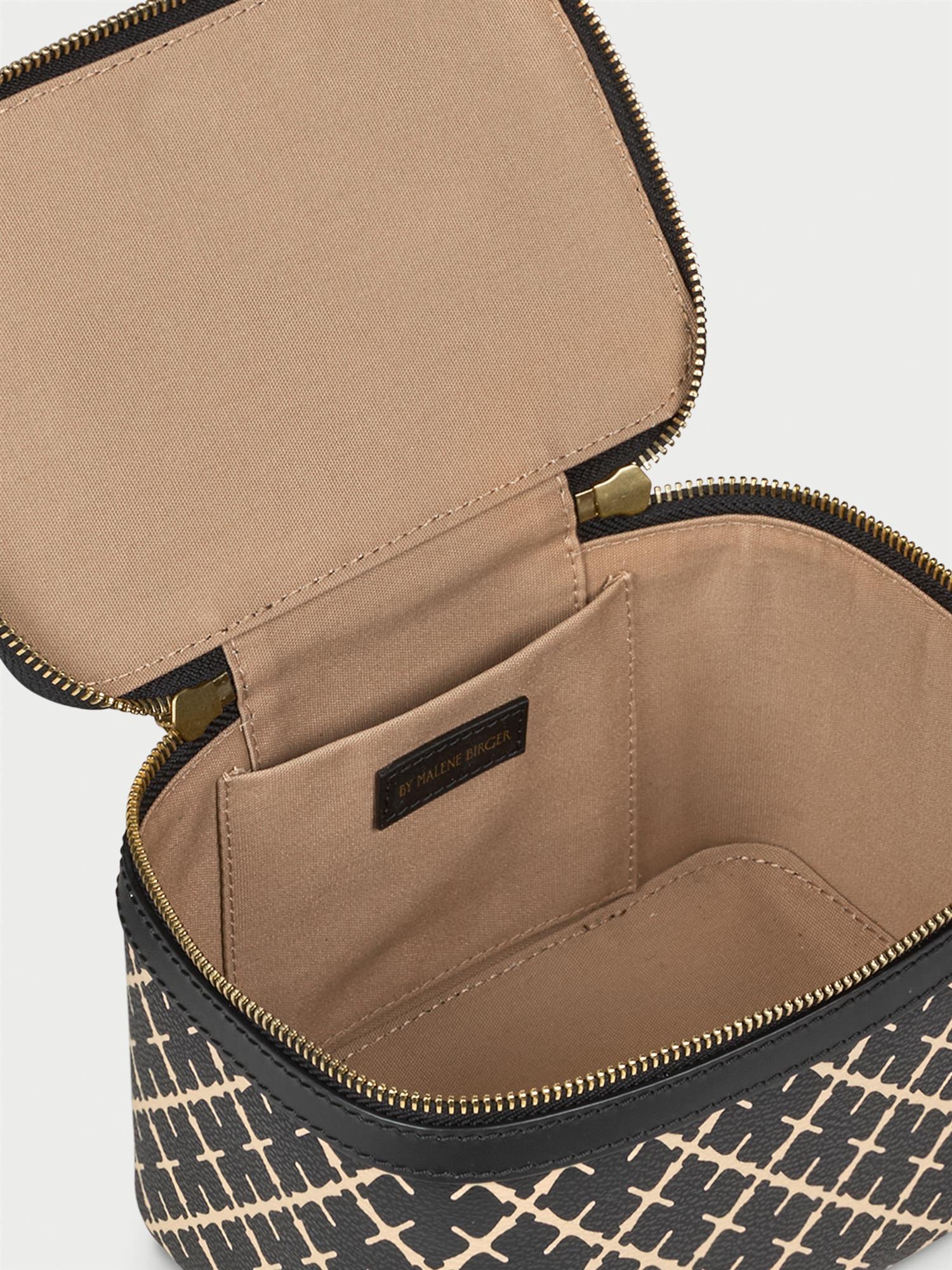 BAE BEAUTY SMALL toalettmappe fra By Malene Birger i fargen sort, laget i 100% polyvinylklorid med Signatur Flower print. Foret med cotton canvas, innvendig lomme og dobbel glidelås.