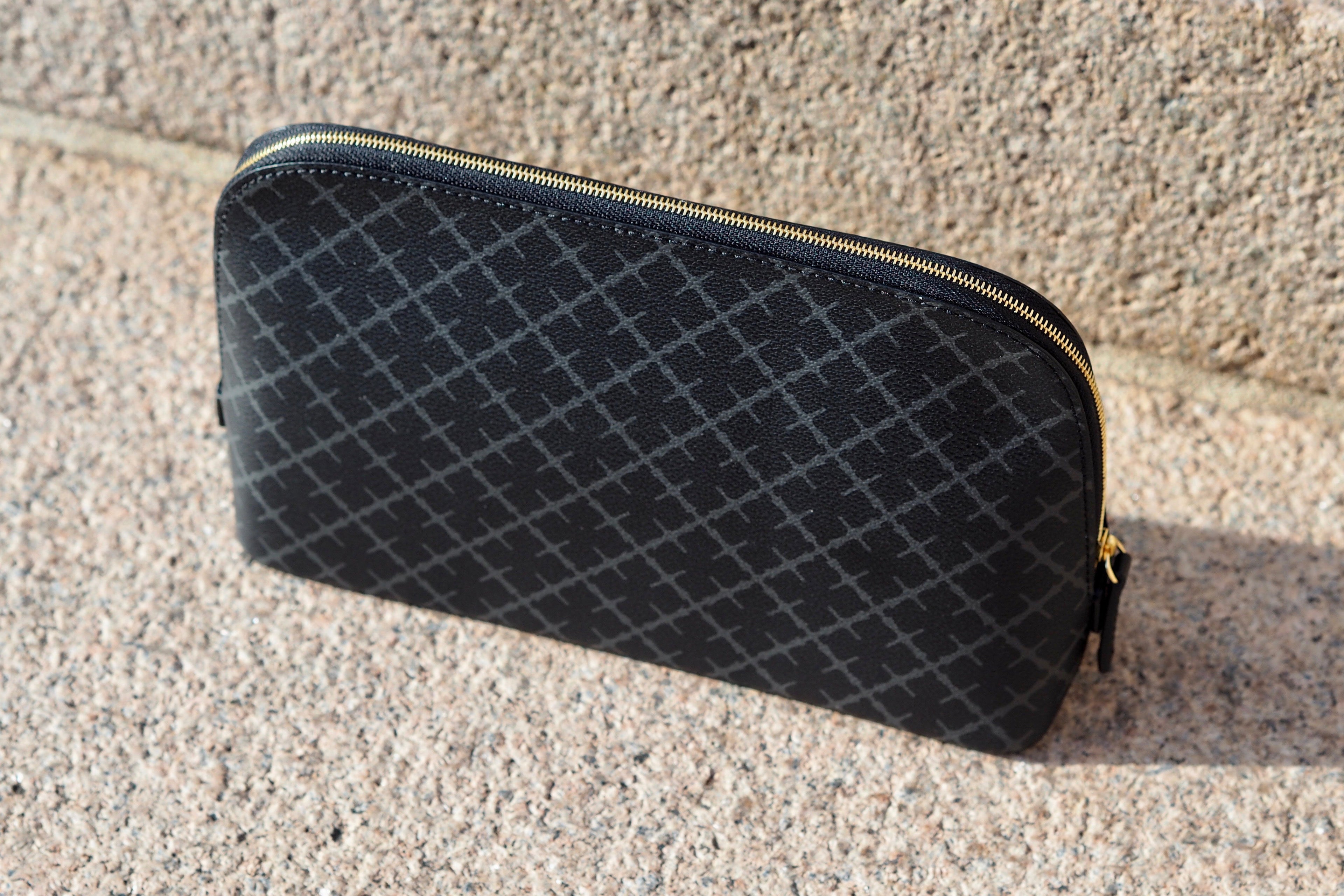 By Malene Birger Bae medium toalettmappe i koksgrå, laget av polyvinylklorid, med skinndetaljer og et slitesterkt bomullsmateriale på innsiden.