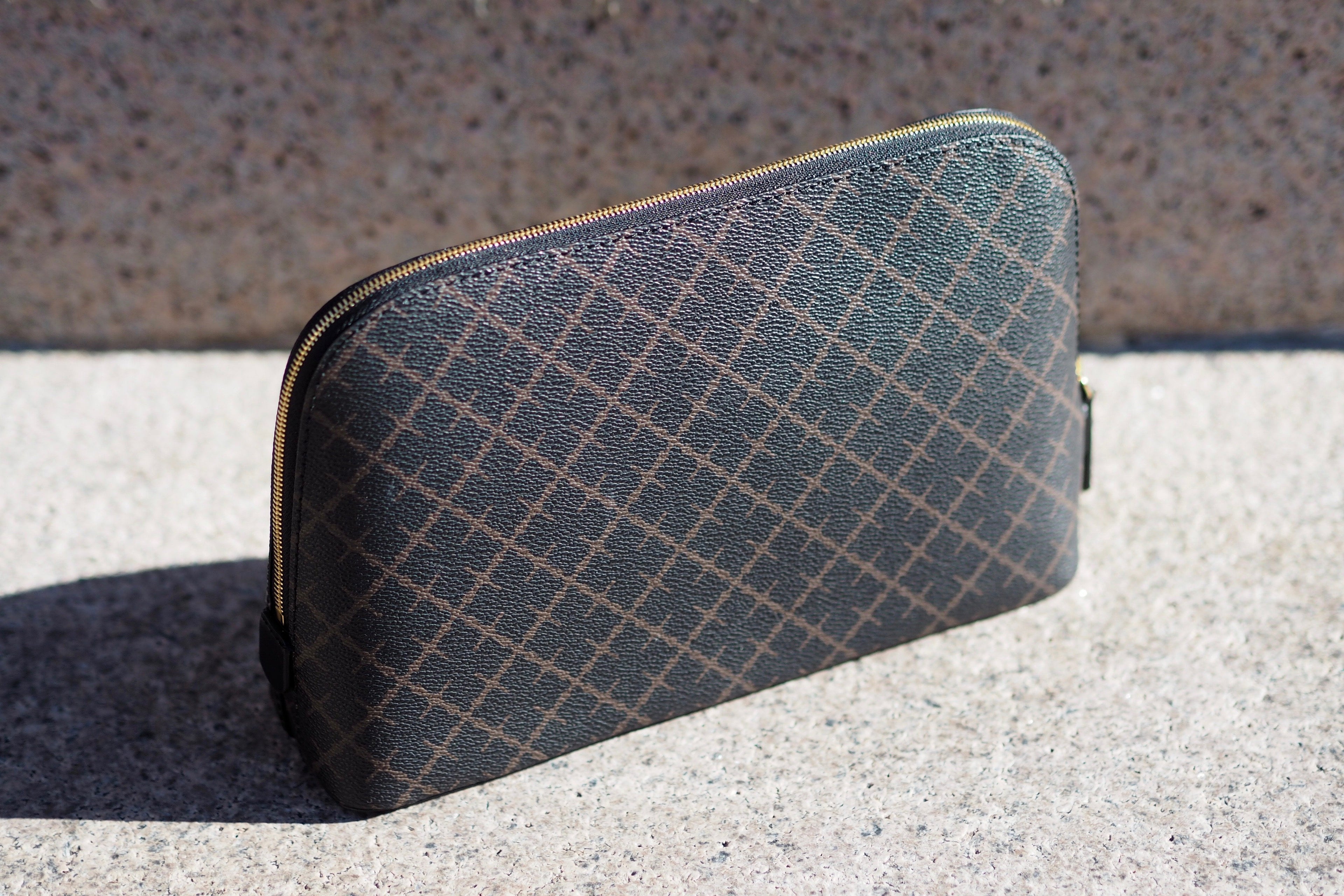 By Malene Birger Bae medium toalettmappe i mørkebrun, laget av polyvinylklorid, med skinndetaljer og et slitesterkt bomullsmateriale på innsiden.