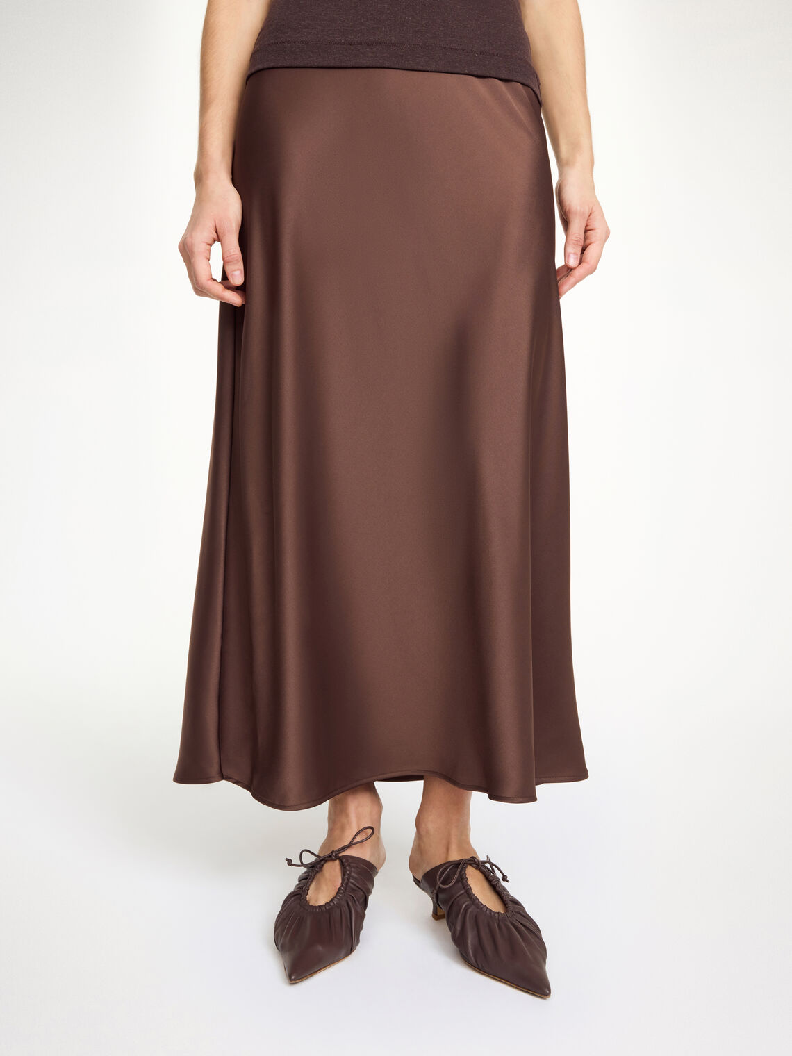 By Malene Birger Boshan skjørt i mørkebrun, med asymmetrisk snitt og elegant stil, laget av en blanding av acetat og polyester.

