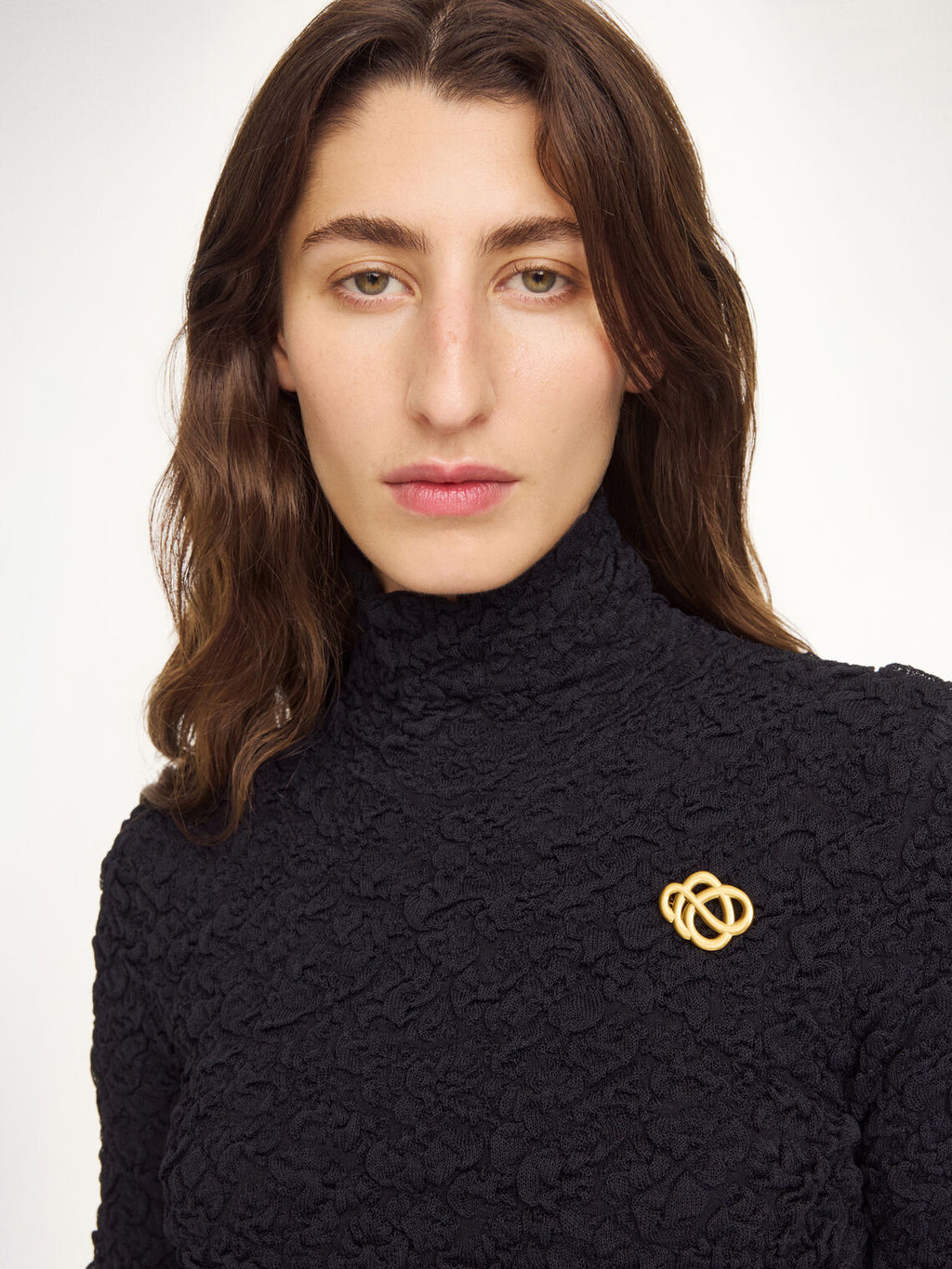 By Malene Birger Broche mini brosje i gullfarget sink, med myke linjer og et tidløst Swirl-motiv.