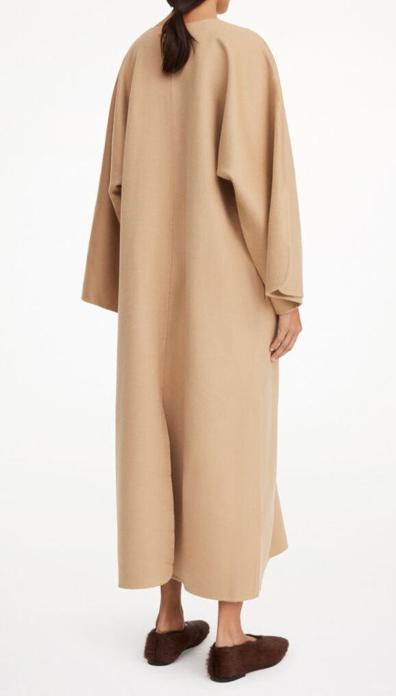 By Malene Birger Cais kjole i beige, laget av 100% ull, med en løs passform, v-utringning og splitt på ermene.