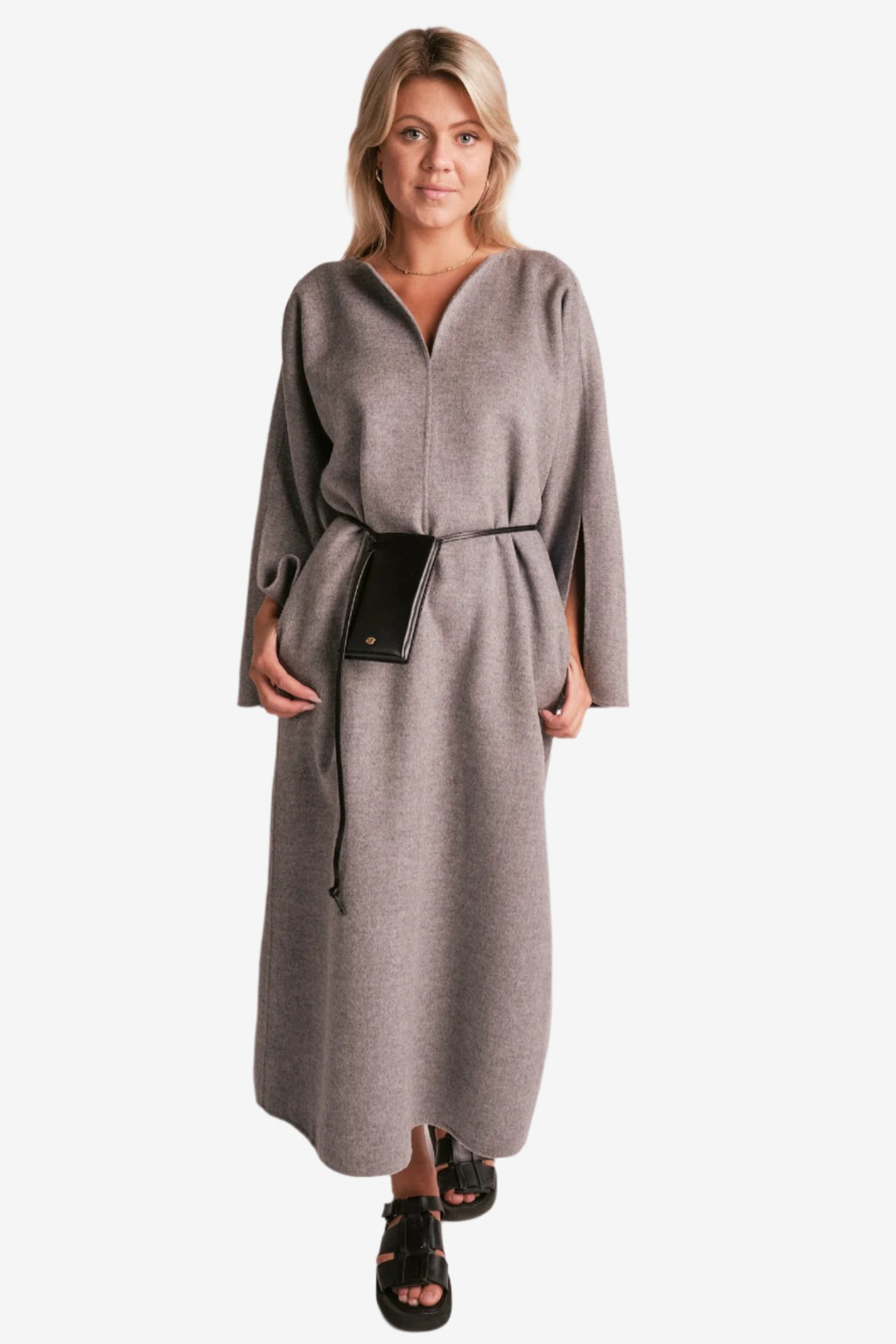 By Malene Birger Cais kjole i grått, laget av 100% ull, med en løs passform, v-utringning og splitt på ermene.