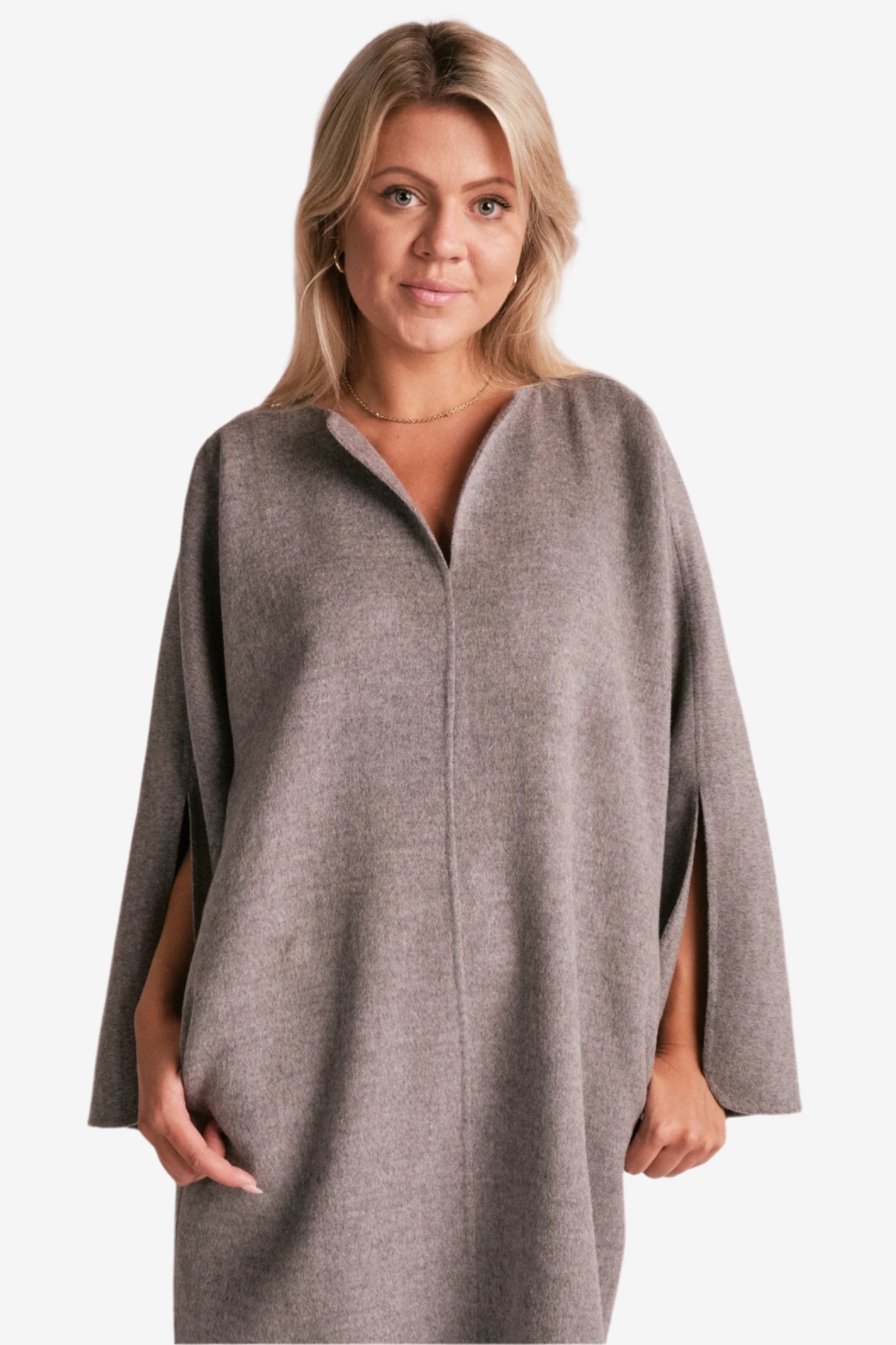 By Malene Birger Cais kjole i grått, laget av 100% ull, med en løs passform, v-utringning og splitt på ermene.