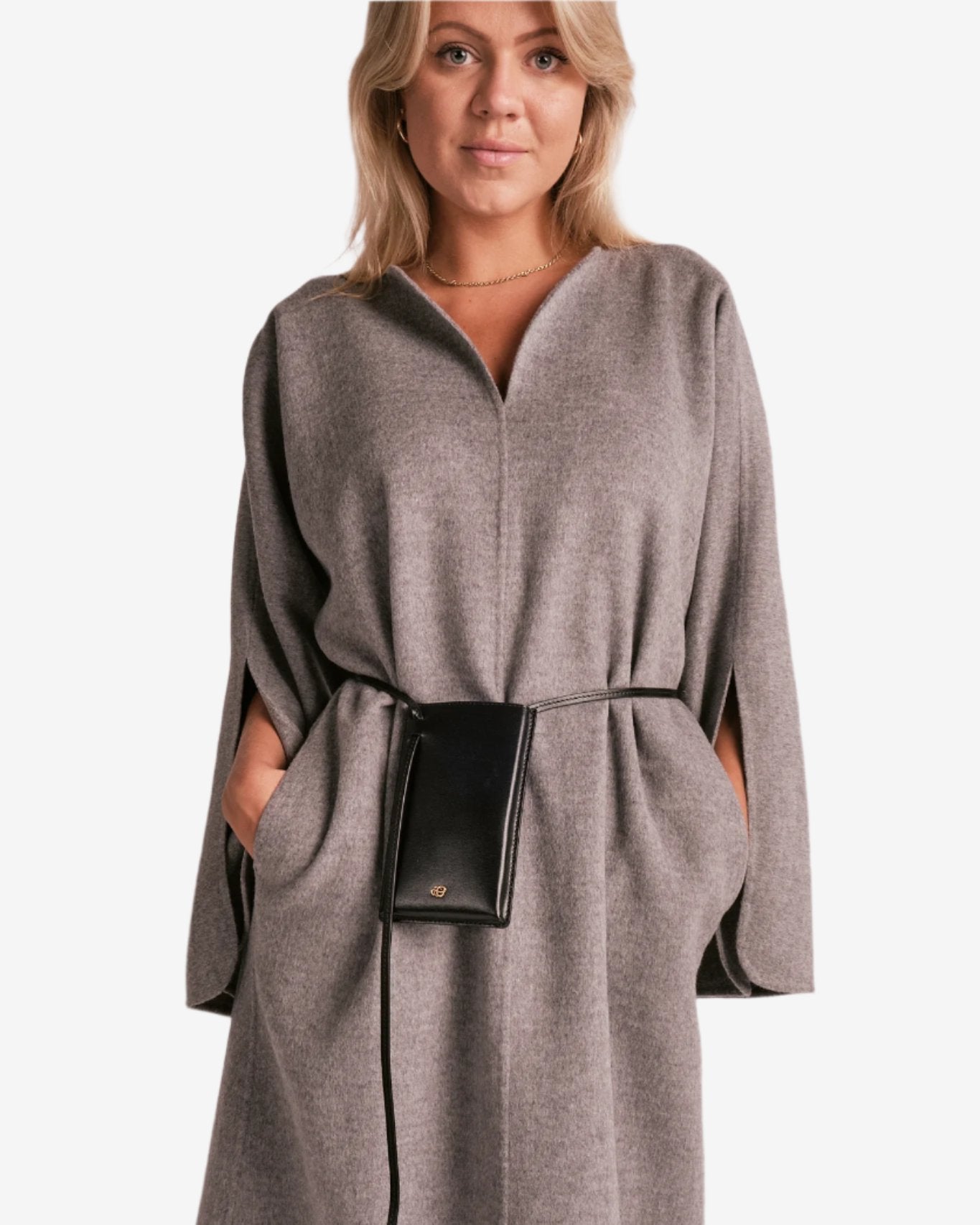 By Malene Birger Cais kjole i grått, laget av 100% ull, med en løs passform, v-utringning og splitt på ermene.