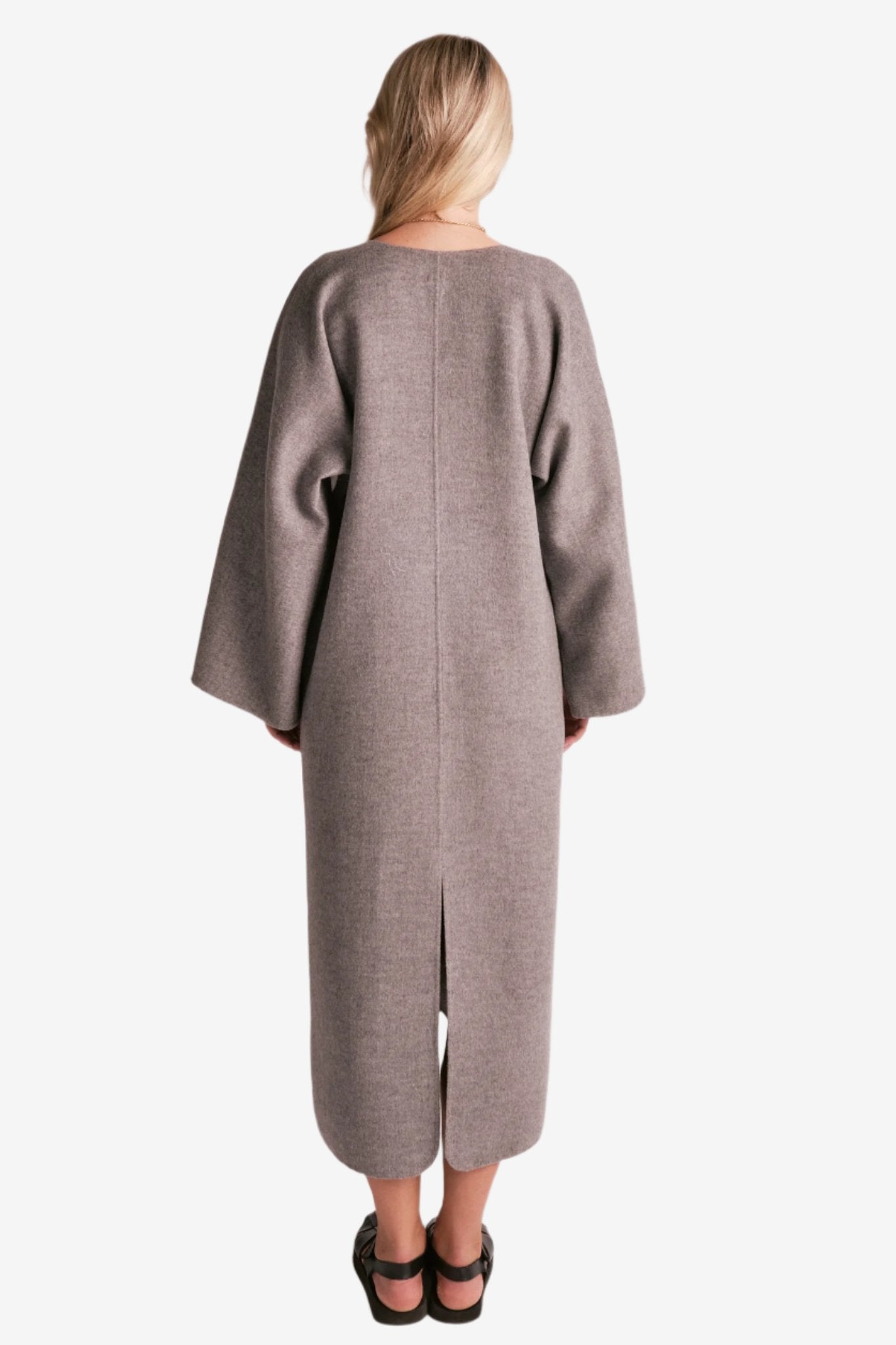 By Malene Birger Cais kjole i grått, laget av 100% ull, med en løs passform, v-utringning og splitt på ermene.