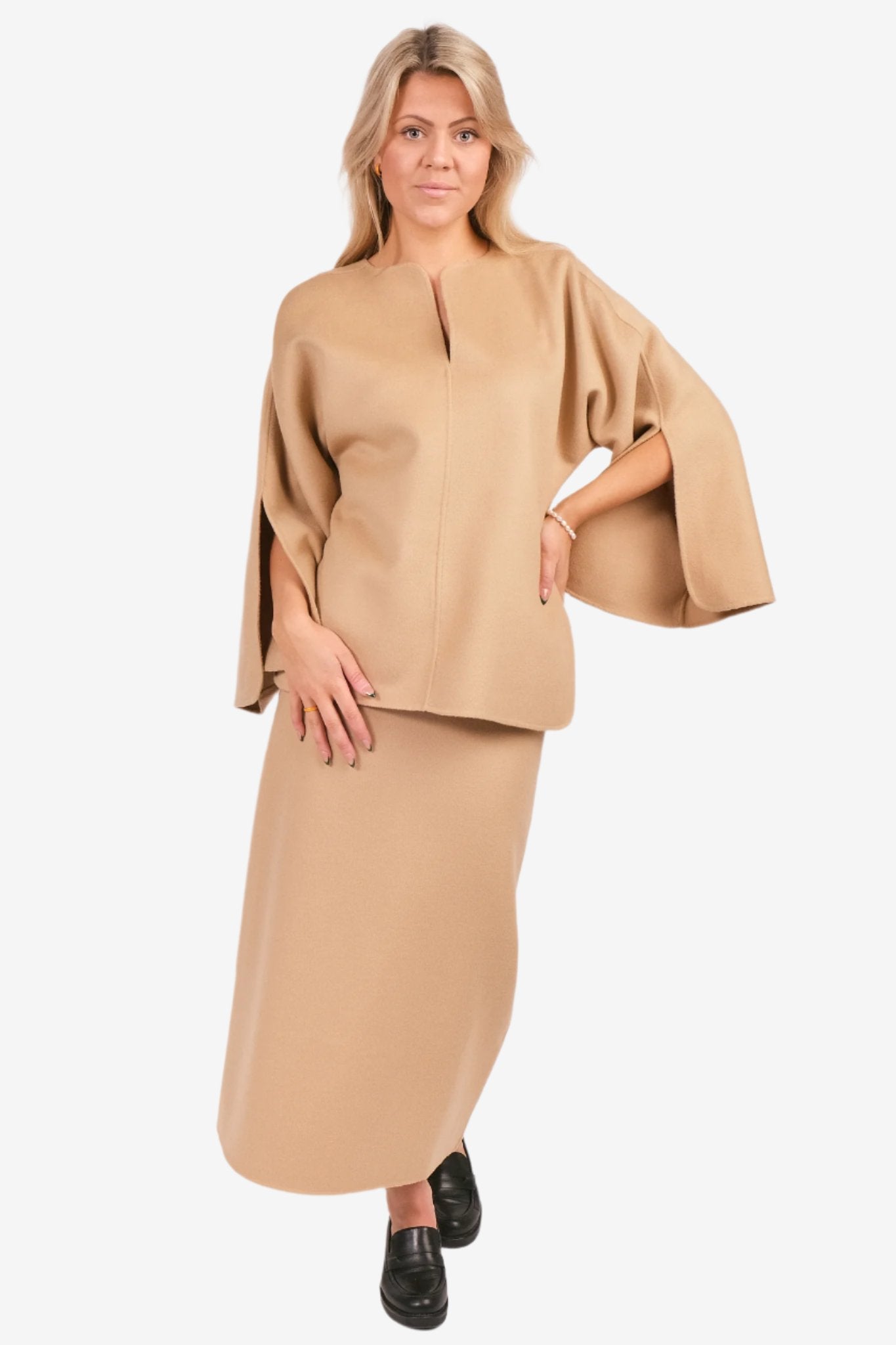 By Malene Birger Calias bluse i beige, med v-utringning og splitt på ermene, laget av 100% ull.