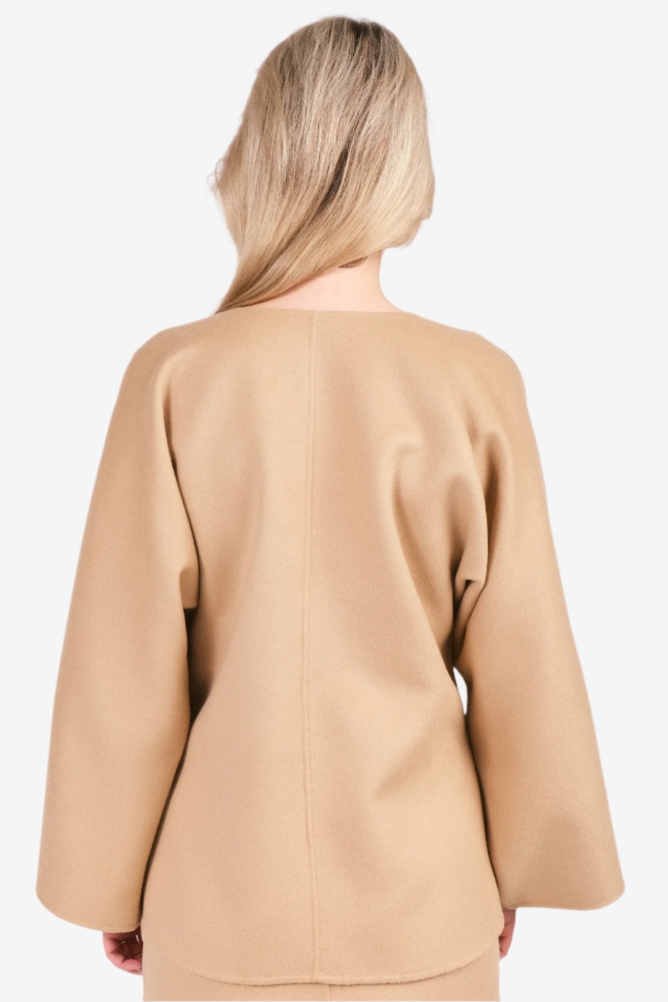 By Malene Birger Calias bluse i beige, med v-utringning og splitt på ermene, laget av 100% ull.