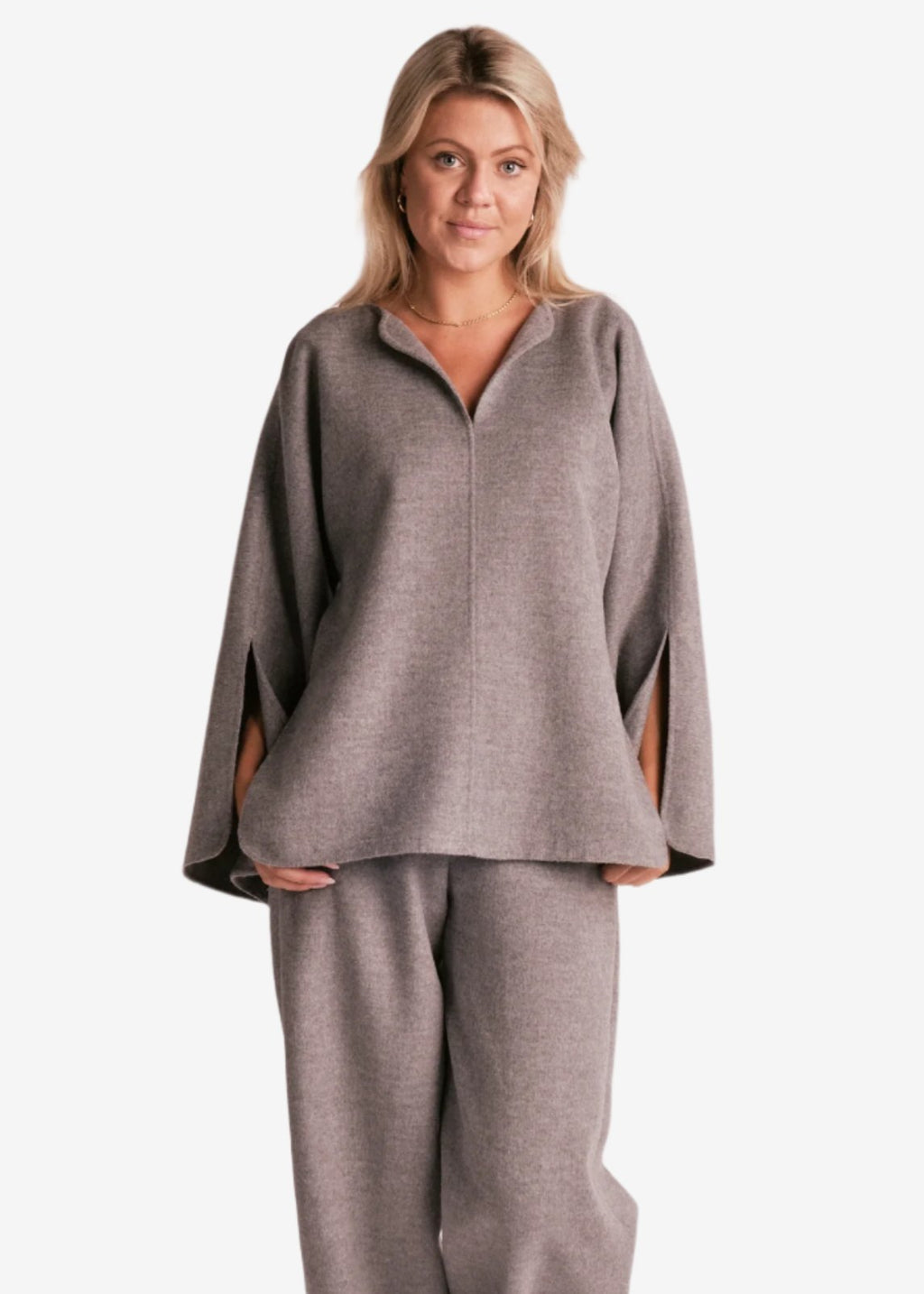 By Malene Birger Calias bluse i grå, laget av 100% ull, med v-utringning og splitt på ermene.