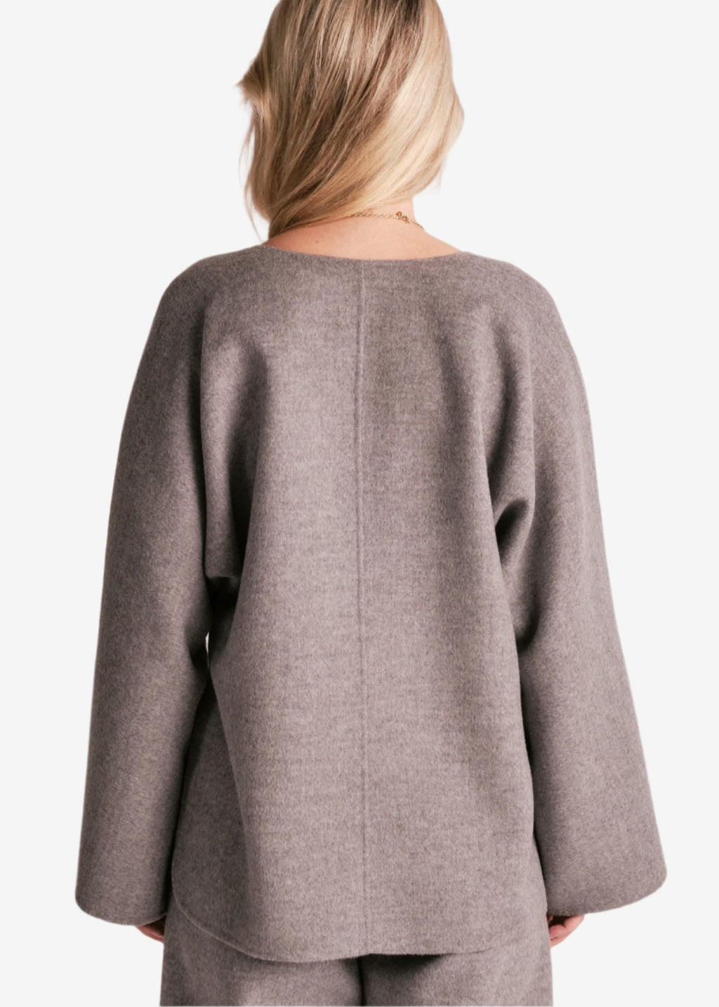 By Malene Birger Calias bluse i grå, laget av 100% ull, med v-utringning og splitt på ermene.