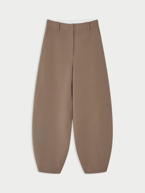 CARLIEN bukse fra By Malene Birger i fargen brun, laget i resirkulert polyester, viskose og elastan. Flatterende kongleform med høyt liv.