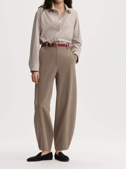 CARLIEN bukse fra By Malene Birger i fargen brun, laget i resirkulert polyester, viskose og elastan. Flatterende kongleform med høyt liv.