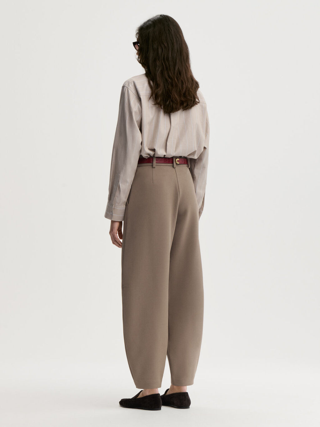 CARLIEN bukse fra By Malene Birger i fargen brun, laget i resirkulert polyester, viskose og elastan. Flatterende kongleform med høyt liv.