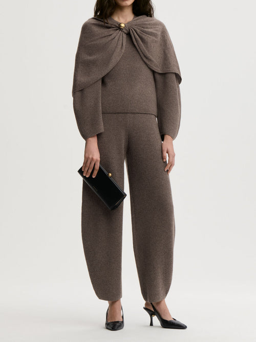 CARMELA bukse fra By Malene Birger i fargen brun, laget i 75% merinoull og 25% yak. Strikk i livet og flatterende barrel-ben, lik CARLIEN-buksen.