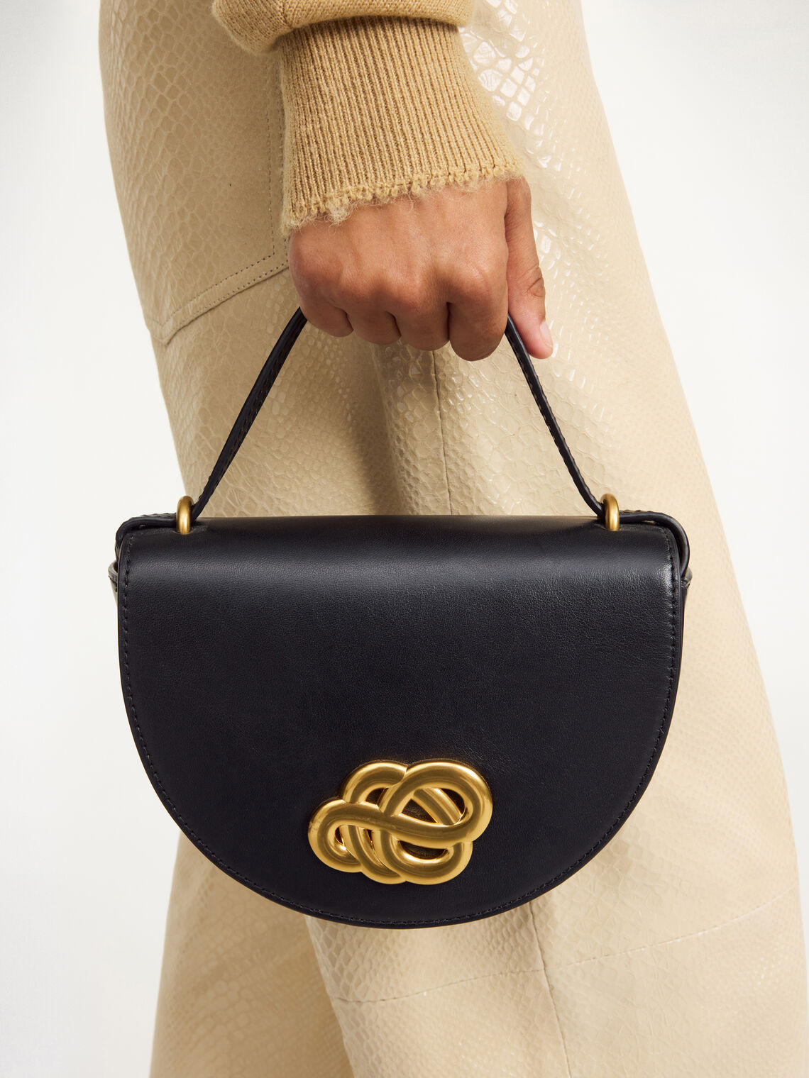 By Malene Birger Cebelle liten veske i sort kuskinn, med Swirl-motiv och justerbar axelrem.