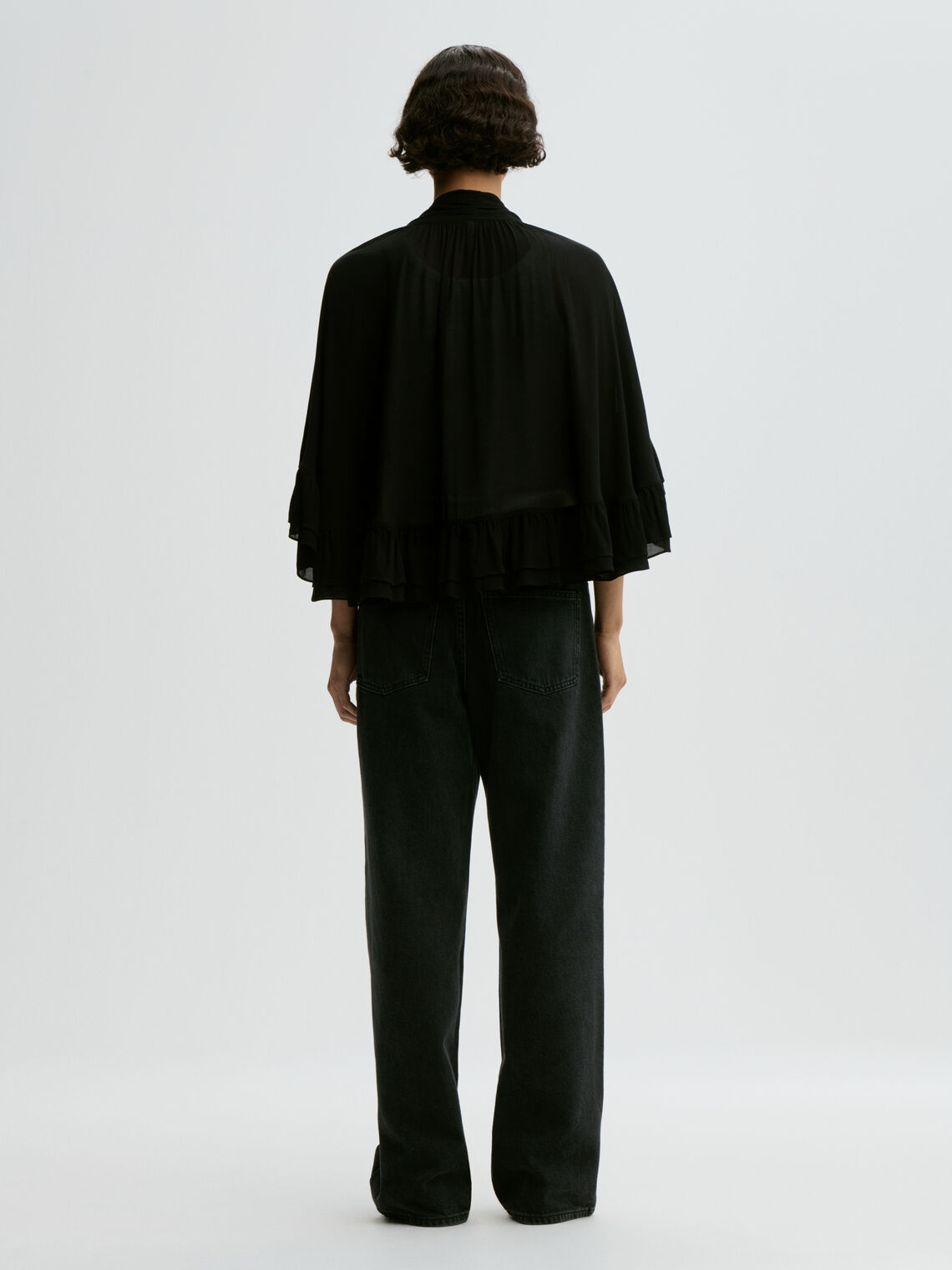 CEDI cape fra By Malene Birger i fargen sort, laget i viskose. Cropped lengde i front, v-utringing og justerbar knyting.