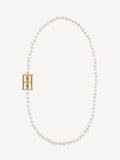 By Malene Birger Chakallo smykke i hvite ferskvannsperler med monogrambrosje, 89 cm langt.