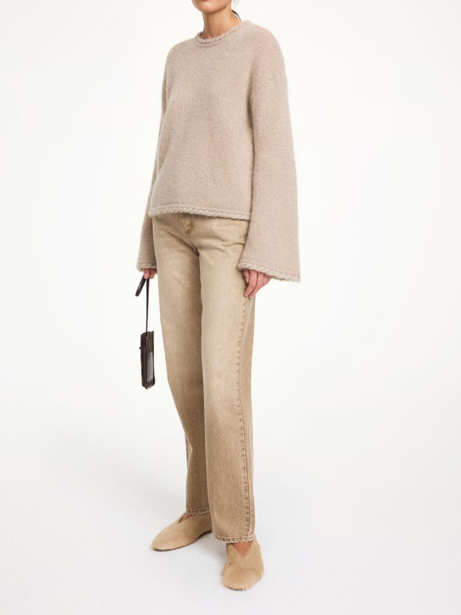 By Malene Birger Cierra genser i beige, med "flette-strikk" detaljer og trompetformede ermer, laget av ull, mohair og polyamid.