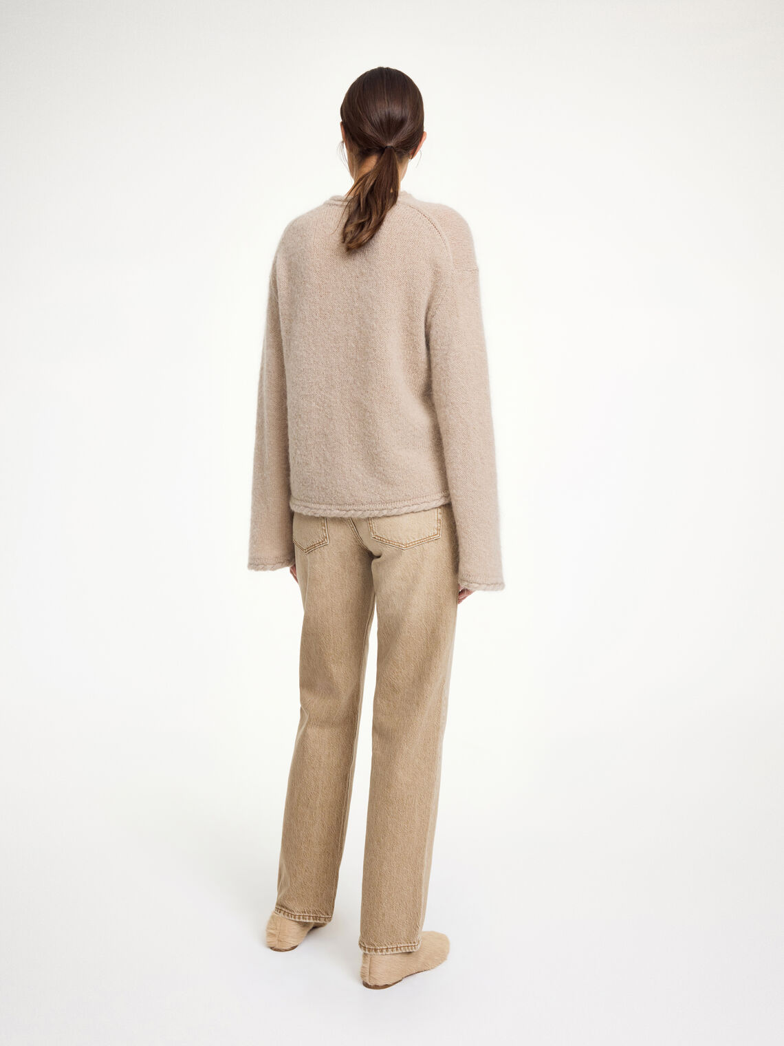 By Malene Birger Cierra genser i beige, med "flette-strikk" detaljer og trompetformede ermer, laget av ull, mohair og polyamid.