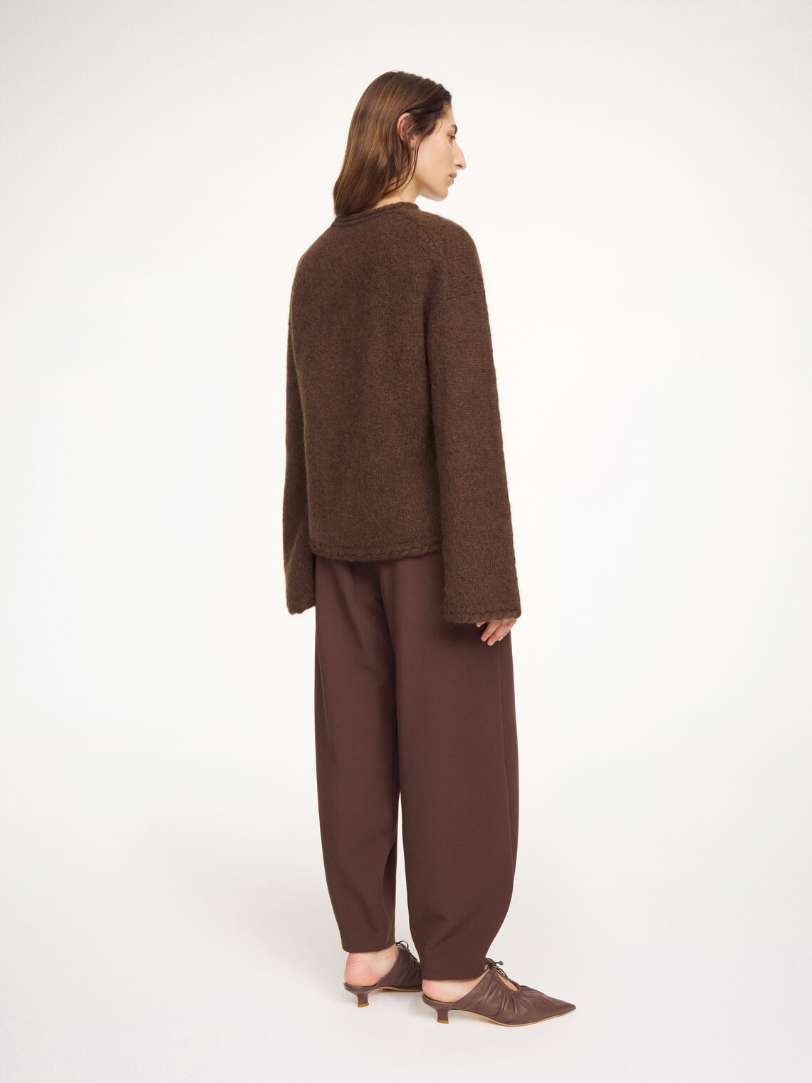 By Malene Birger Cierra genser i mørkebrun, med "flette-strikk" detaljer og trompetformede ermer, laget av ull, mohair og polyamid.