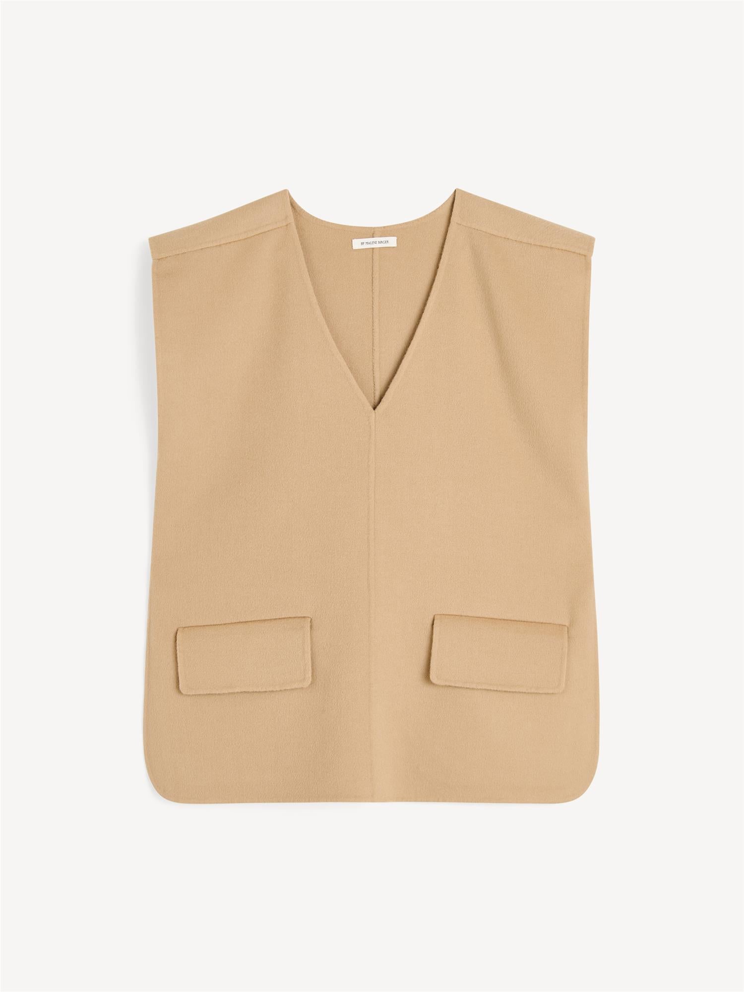 By Malene Birger Cilia vest i beige, laget av 100% ull, med en oversized passform, splitt i sidene og v-utringning.
