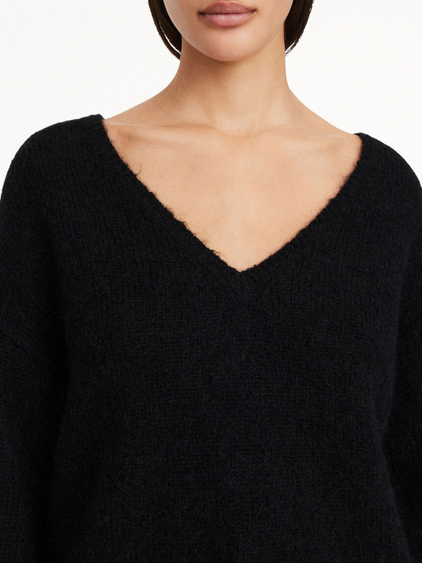 By Malene Birger Cimone genser i sort, med nett V-utringning, laget av en blanding av ull, mohair og polyamid.