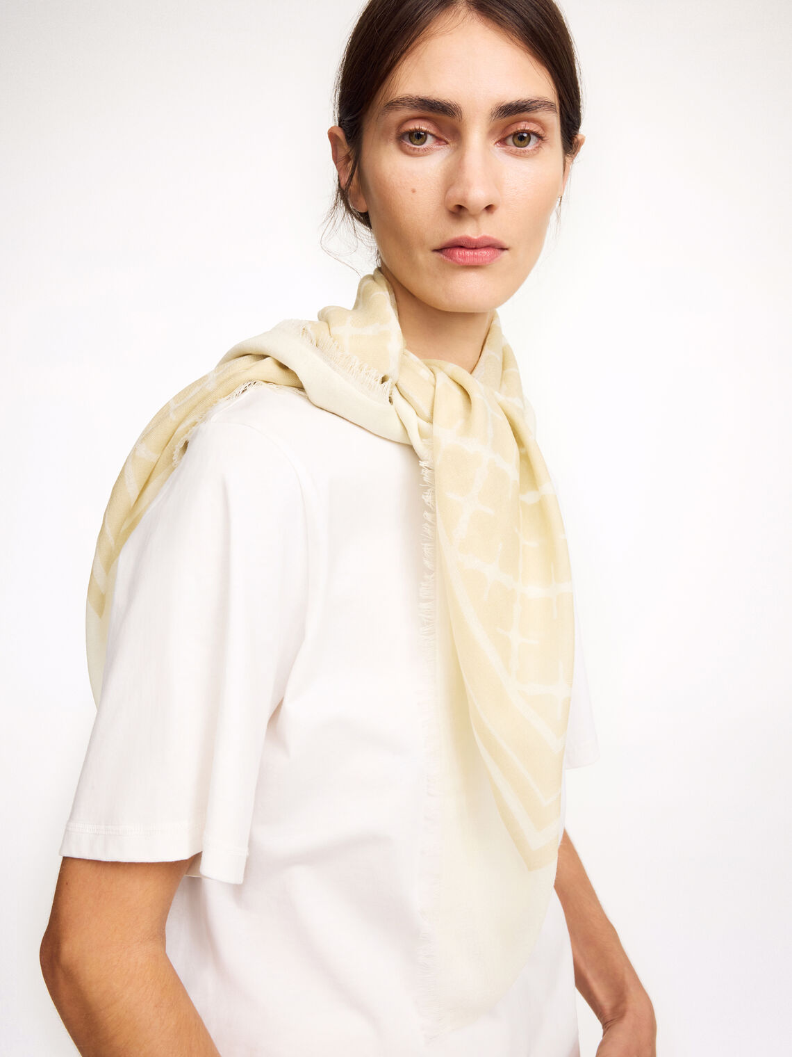 By Malene Birger Cornelis skjerf i kremfarget, laget av 100% ull med Signature Flower-print og små frynser på sidene.