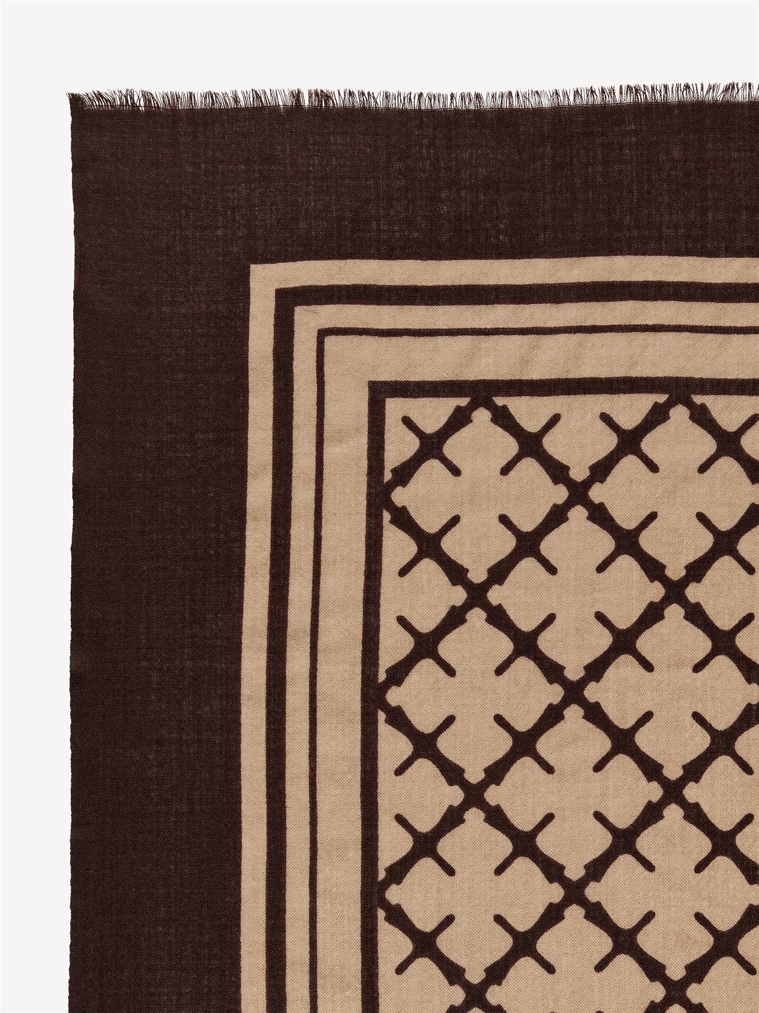 By Malene Birger Cornelis skjerf i mørkebrun, laget av 100% ull med Signature Flower-print og små frynser på sidene.