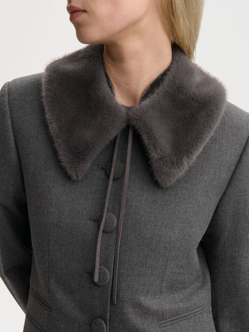 COWIE skjerf fra By Malene Birger i fargen mørkegrå, laget i faux fur (100% polyester). Knytes i halsen med smale skinnsnorer og er foret.