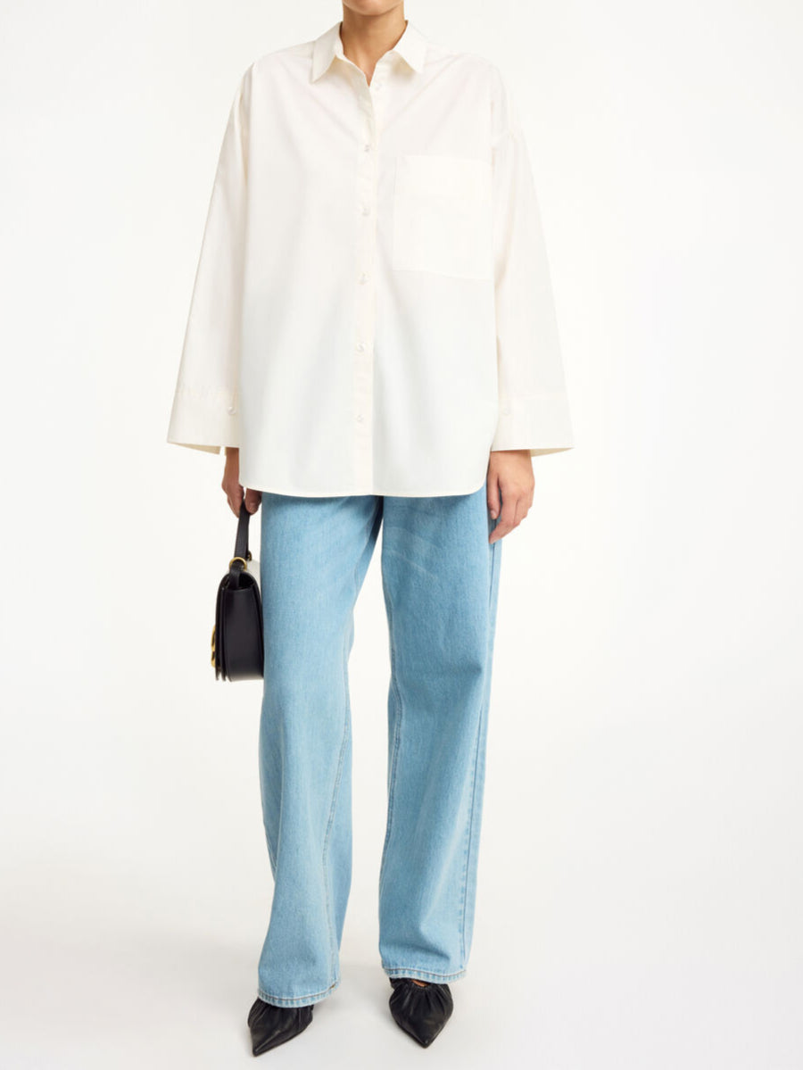 By Malene Birger Derris bomullskjorte i kremfarget, med en oversized passform og brystlomme, laget av 100% organisk bomull.