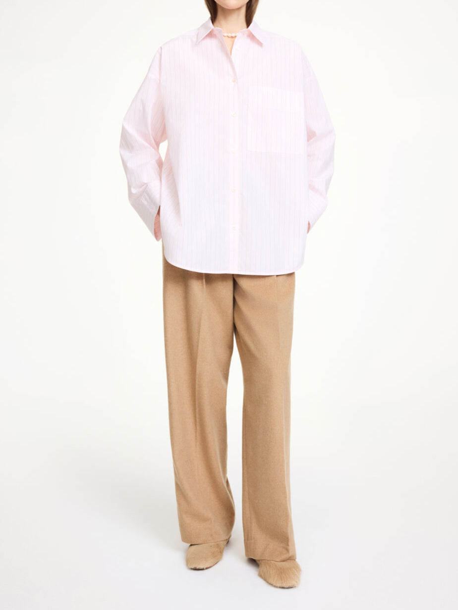 By Malene Birger Derris bomullskjorte i rosa, med tynne røde striper og en oversized passform, laget av 100% organisk bomull.