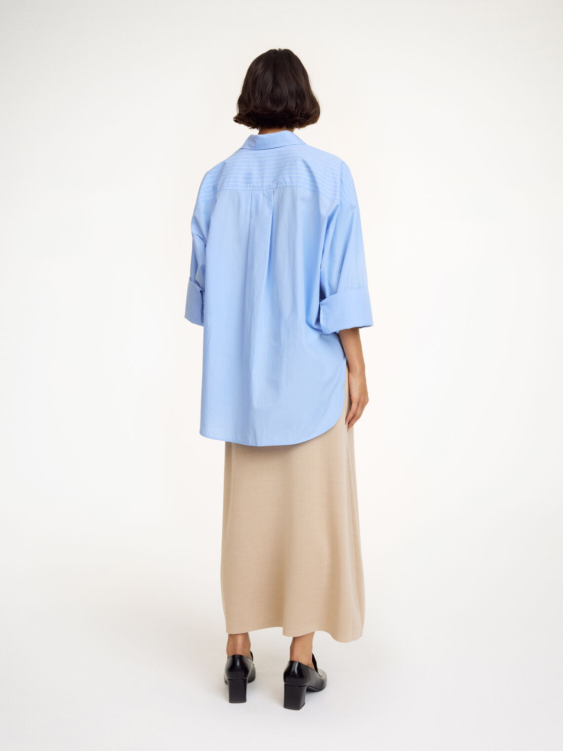 By Malene Birger Derris oversized bomullsskjorte i lyseblå med hvite striper, baksidedetalj med legg og knapper.