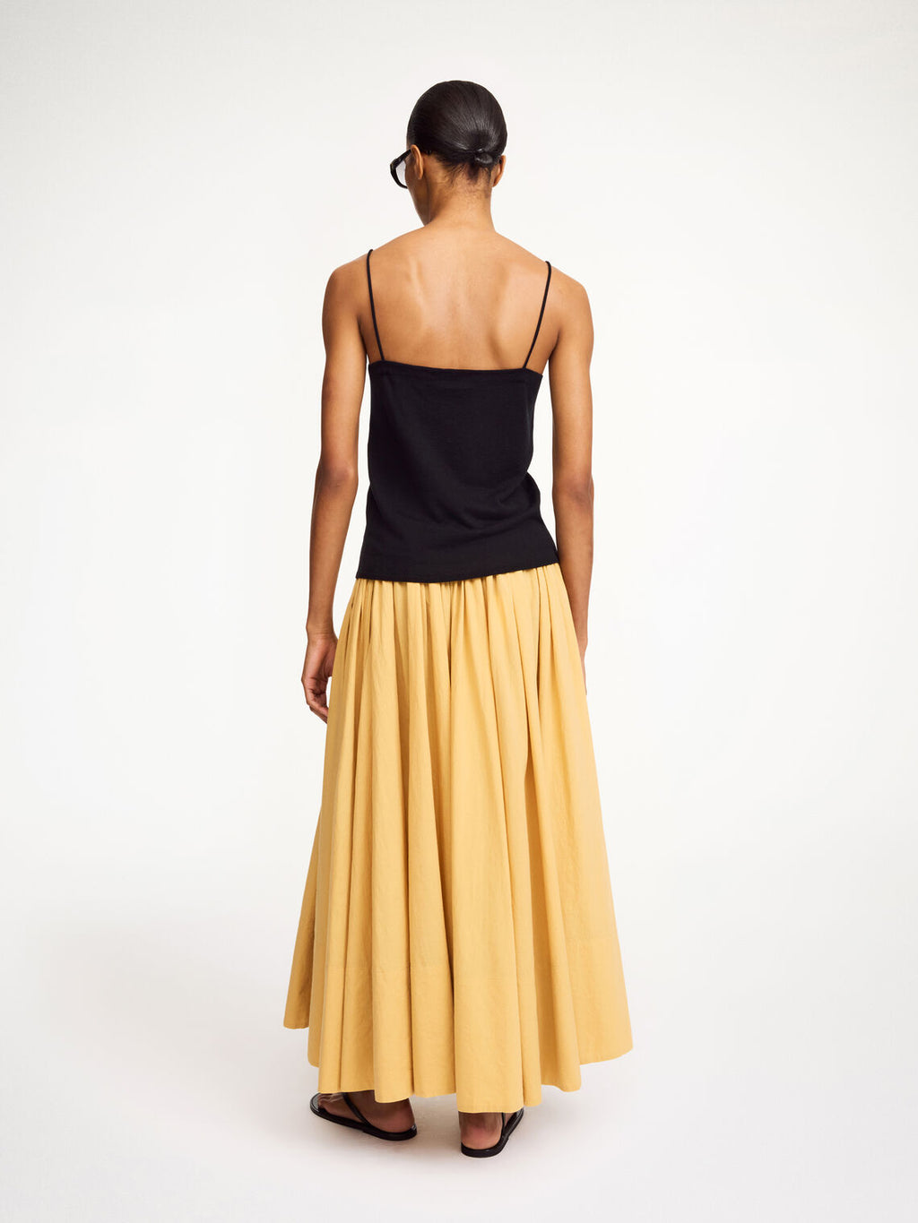 By Malene Birger Edel topp i sort, laget av en blanding av lyocell, ull og silke, med spaghettistropper og et flatterende design.