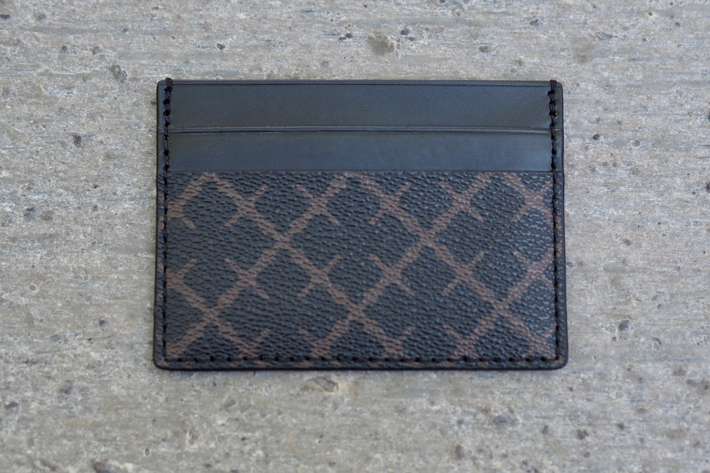 By Malene Birger Elia Card kortholder i brun, laget av 100% polyvinylklorid, med Signature Flower-print og plass til flere kort.